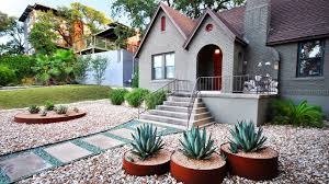 Modern front yard with white decorative rock landscaping, succulents, river rock borders, and xeriscape design