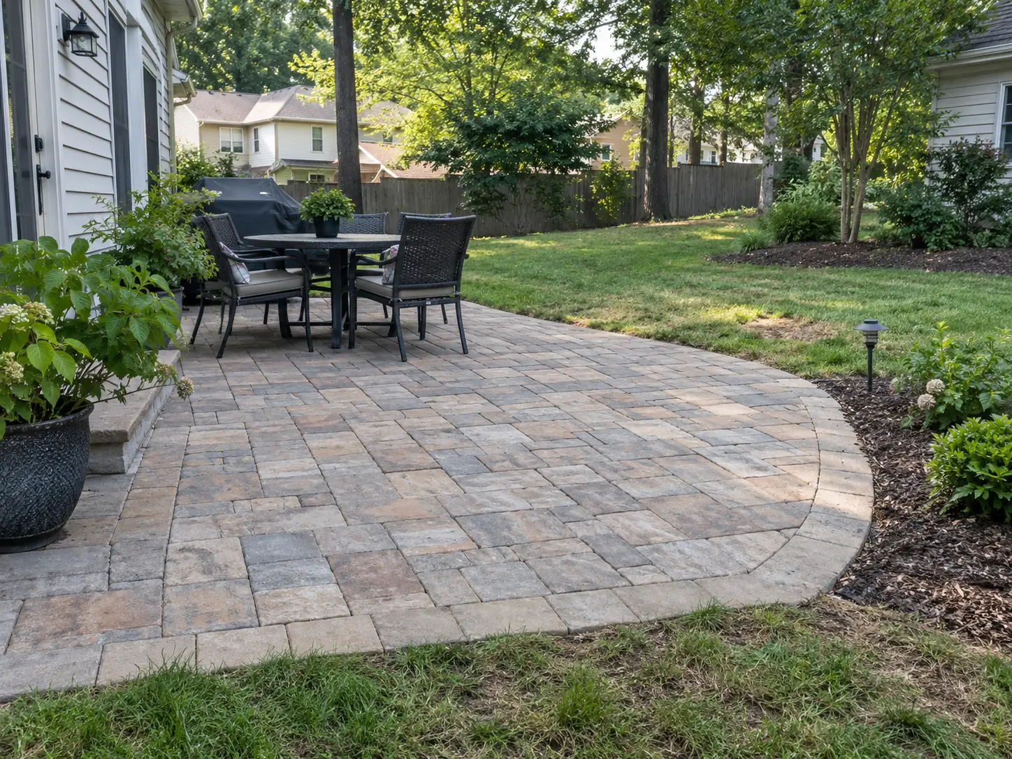 Paver patio with lawn and planting transitions in a residential Charlotte yard